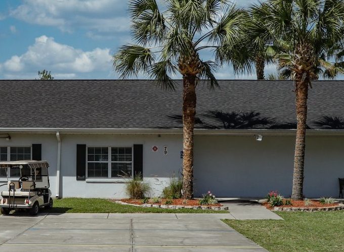 golf cart in front of home with palm trees